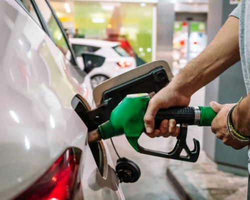 Green Diesel Unrecognizable male putting fuel dispenser in tank while refueling vehicle on self service gas station. High quality photo